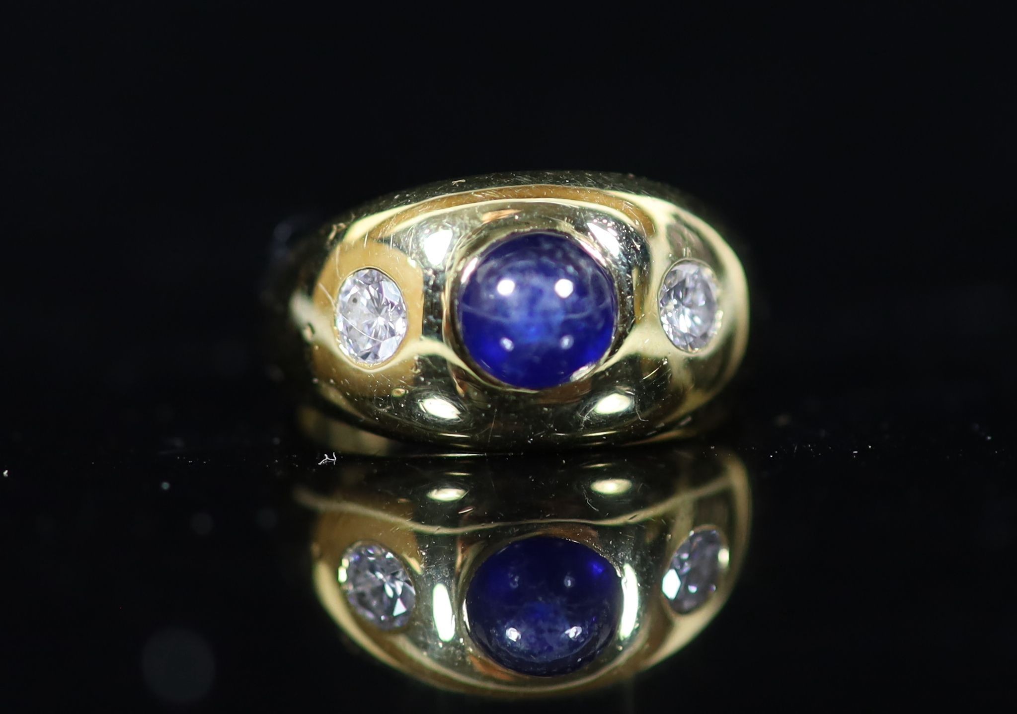 A Cartier 18ct gold , gypsy set cabochon sapphire and two stone diamond ring
